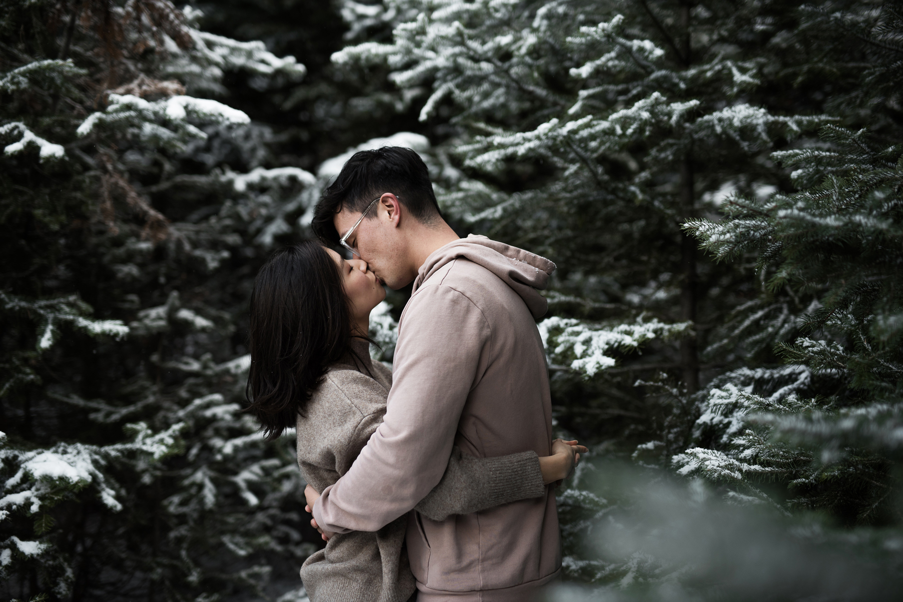 couple cozied up together in snowy mountains