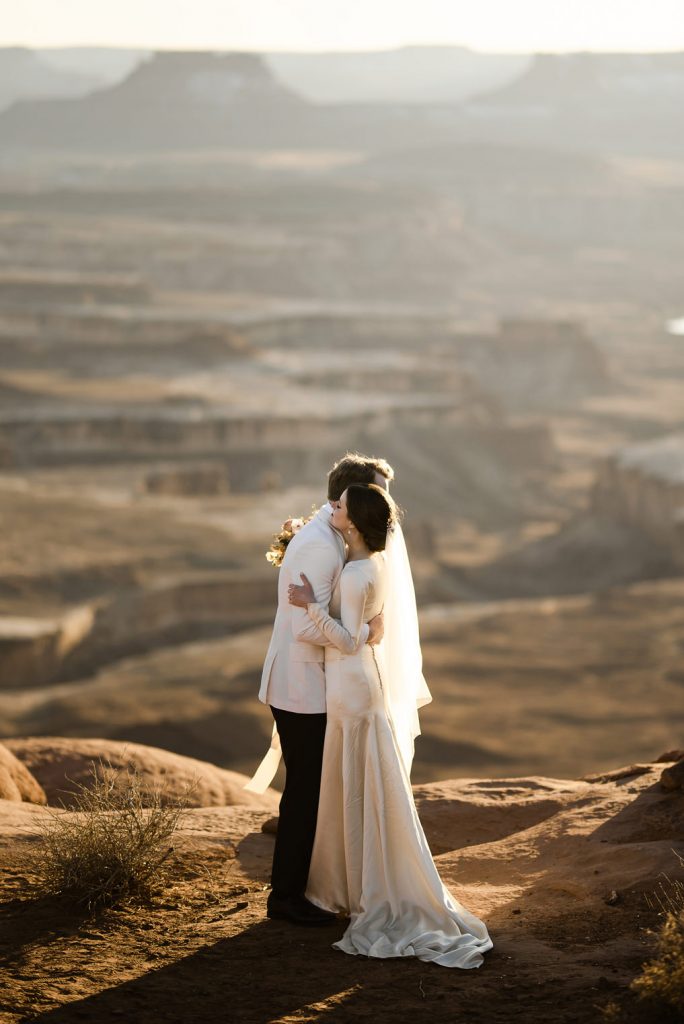 Zach and Grace hug on the side of some southern Utah bluffs.