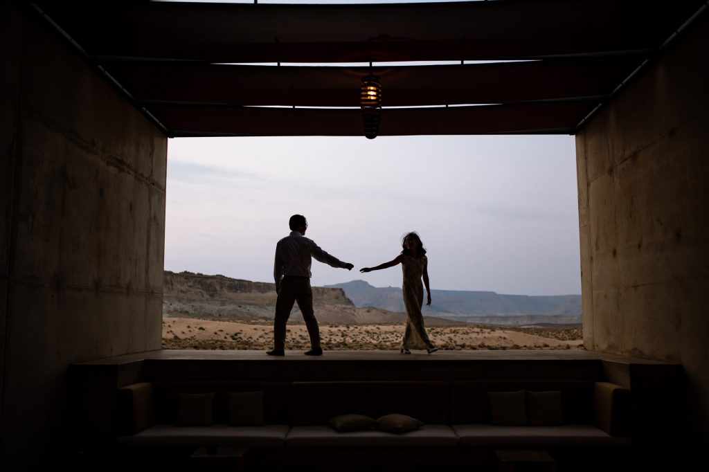 Couple in modern space turning away from each other with the dessert in the distance.