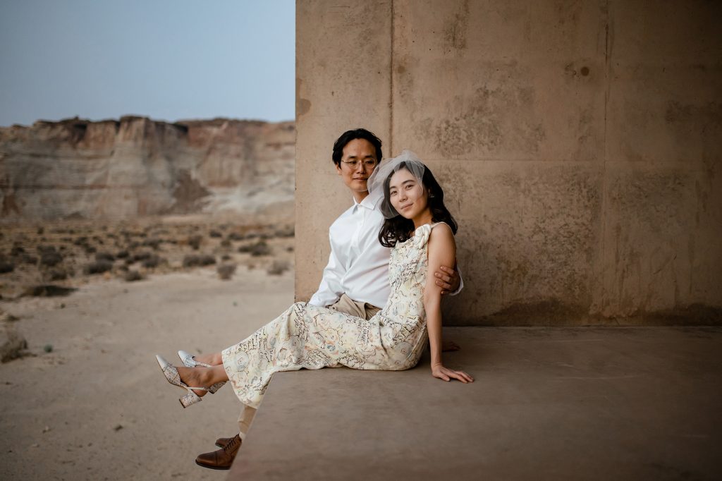 Husband looks at his smiling wife while she smiles at the camera.