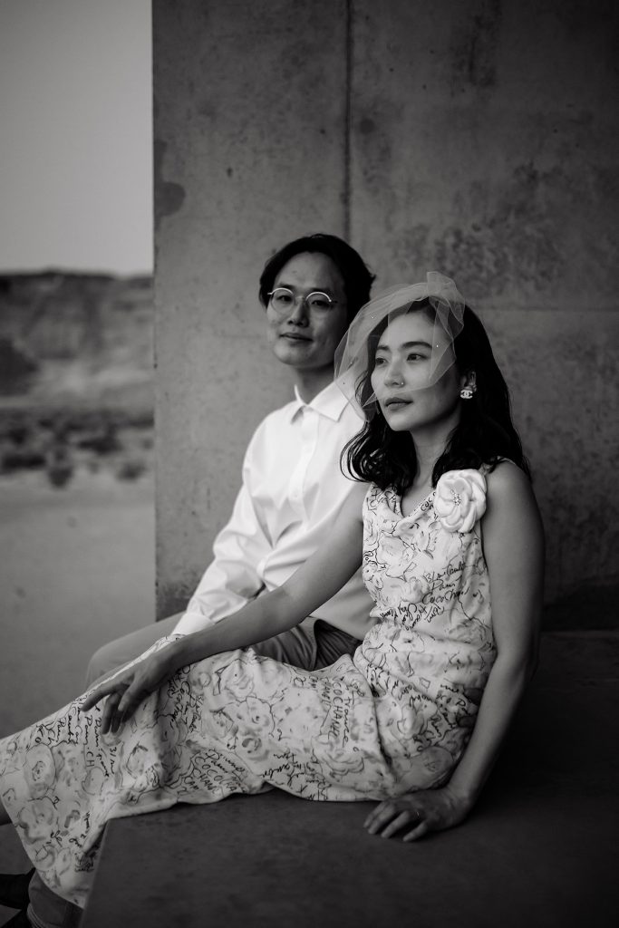 Couple sits on modern concrete structure in the dessert.