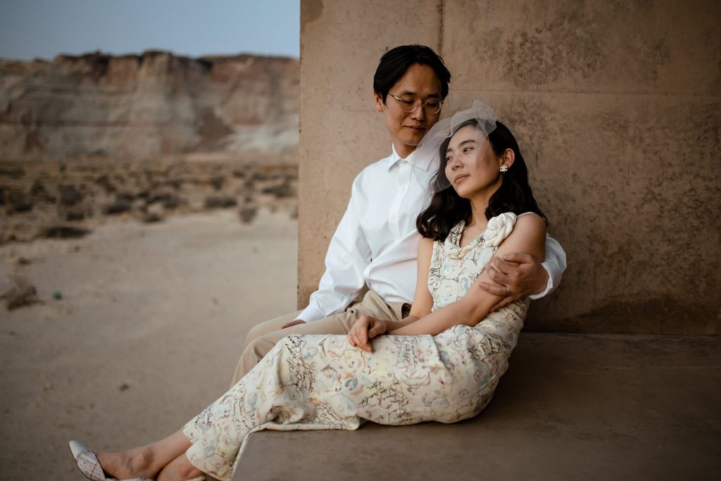 Husband holds his wife while she puts her head on his shoulder.