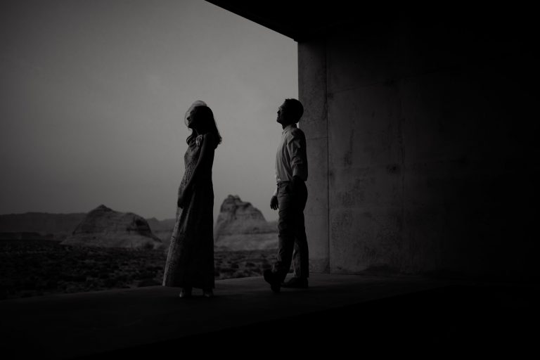 Husband and wife look out towards the dessert sunset from their Amangiri room.