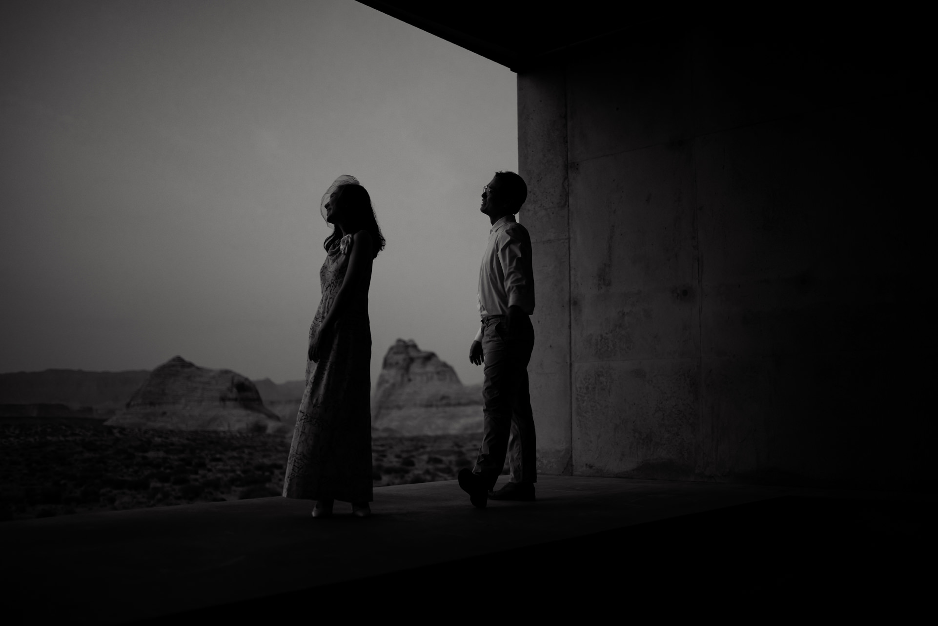 Husband and wife look out towards the dessert sunset from their Amangiri room.