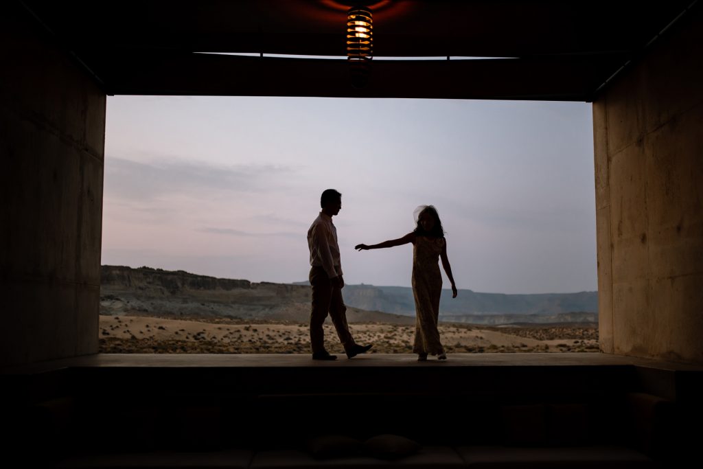 Woman reaching back towards her new husband in the dessert.