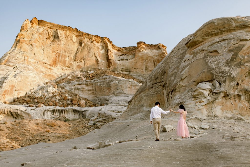 Scenic photo of the desert bluffs with a couple dancing in the foregorund.