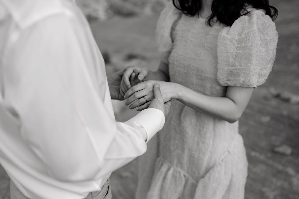 Black and white of the two grabbing each others hands.