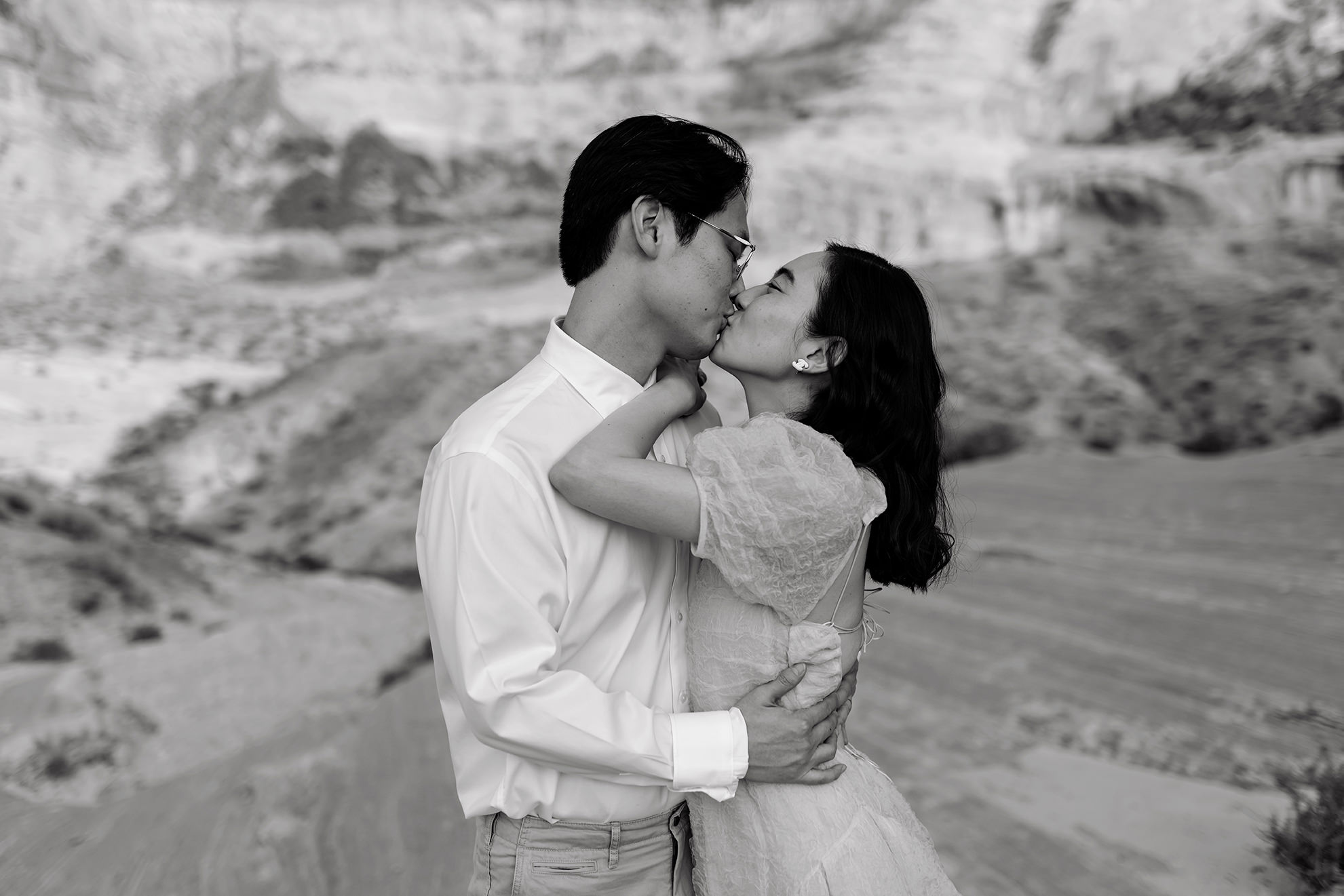 Black and white of Jinoh kissing his wife.