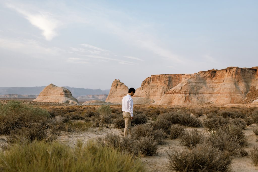 Jinoh contemplates life perhaps as he stands surrounded by the amber and red dessert.