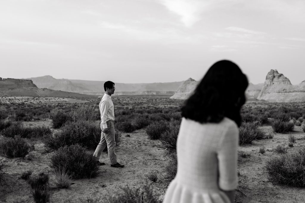 Husband walking towards his wife in black and white.