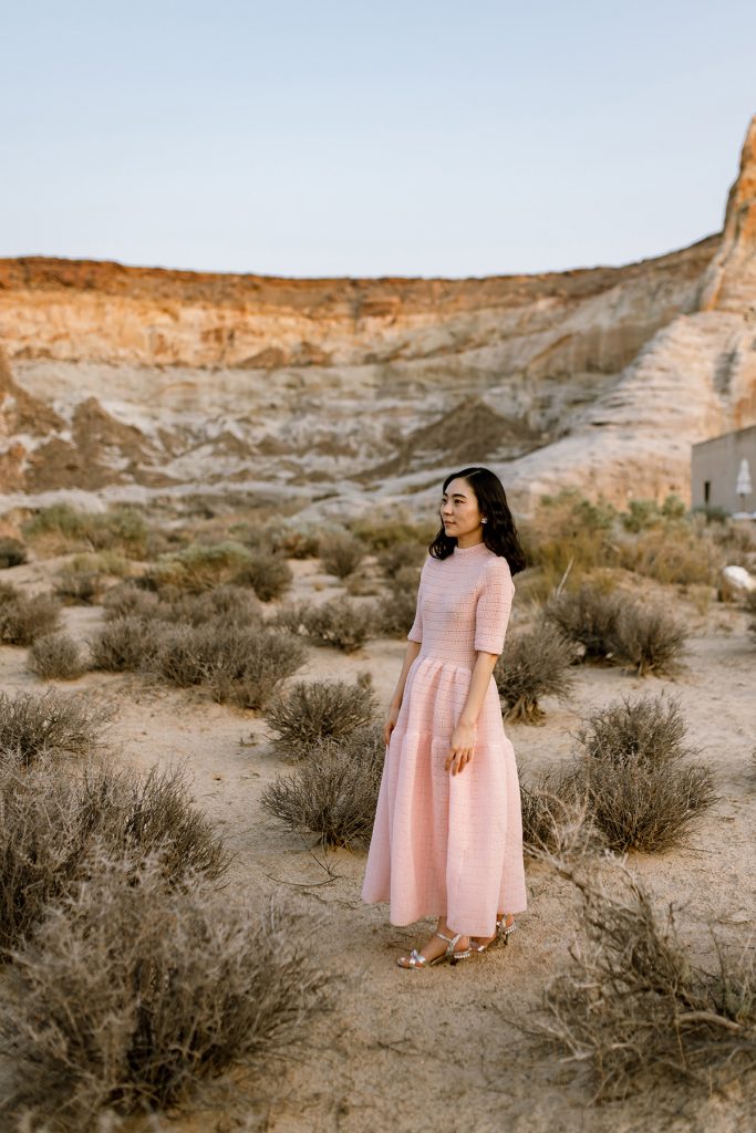 Woman wearing pink dress waiting for her new husband while surrounded by dessert brush.