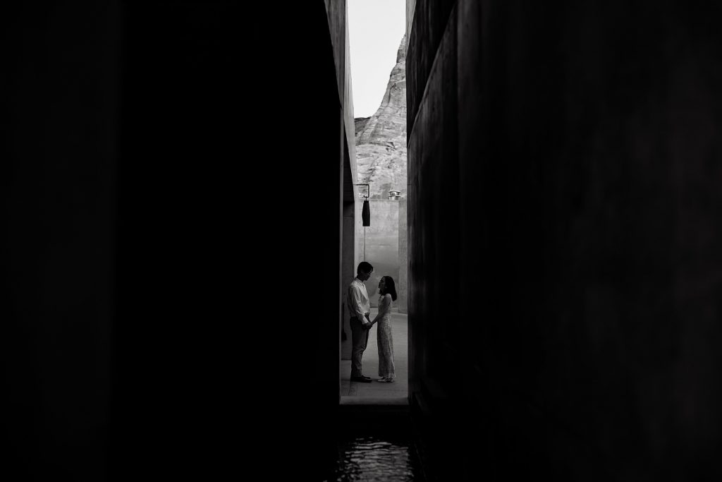 Bride and groom take a moment to themselves down an alley way in black and white.