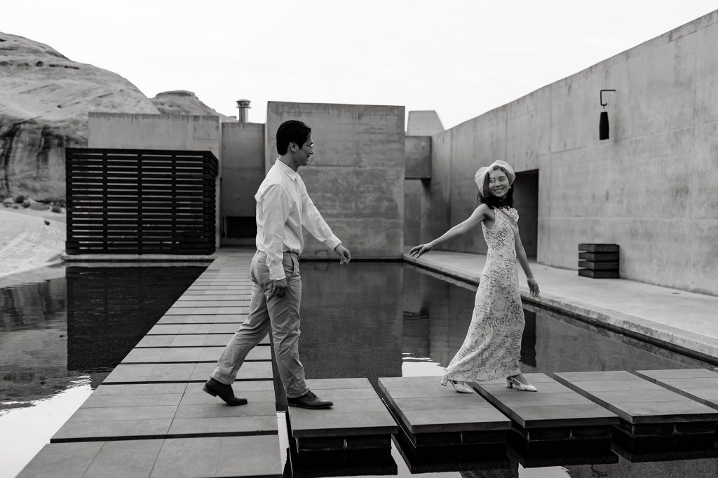 Wife playfully reaches back towards her husband, beckoning him towards Amangiri.