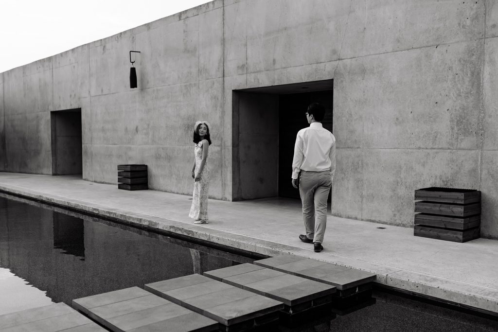 Wife looks back at husband while he walks towards her to go into Amangiri.