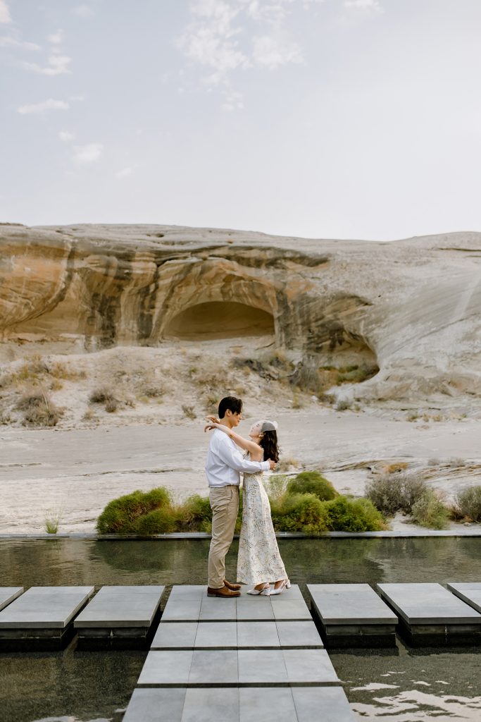 Wife puts her arms around her new husbands neck at Amangiri with the dessert in the background.