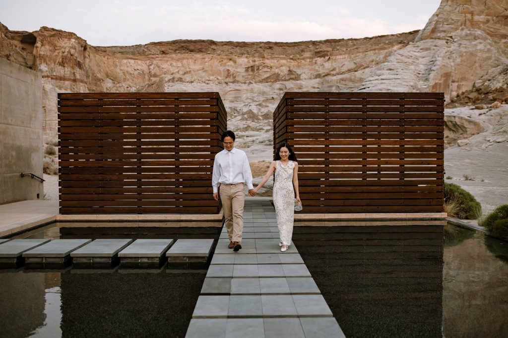 Husband and wife walk through Amangiri courtyard pond.