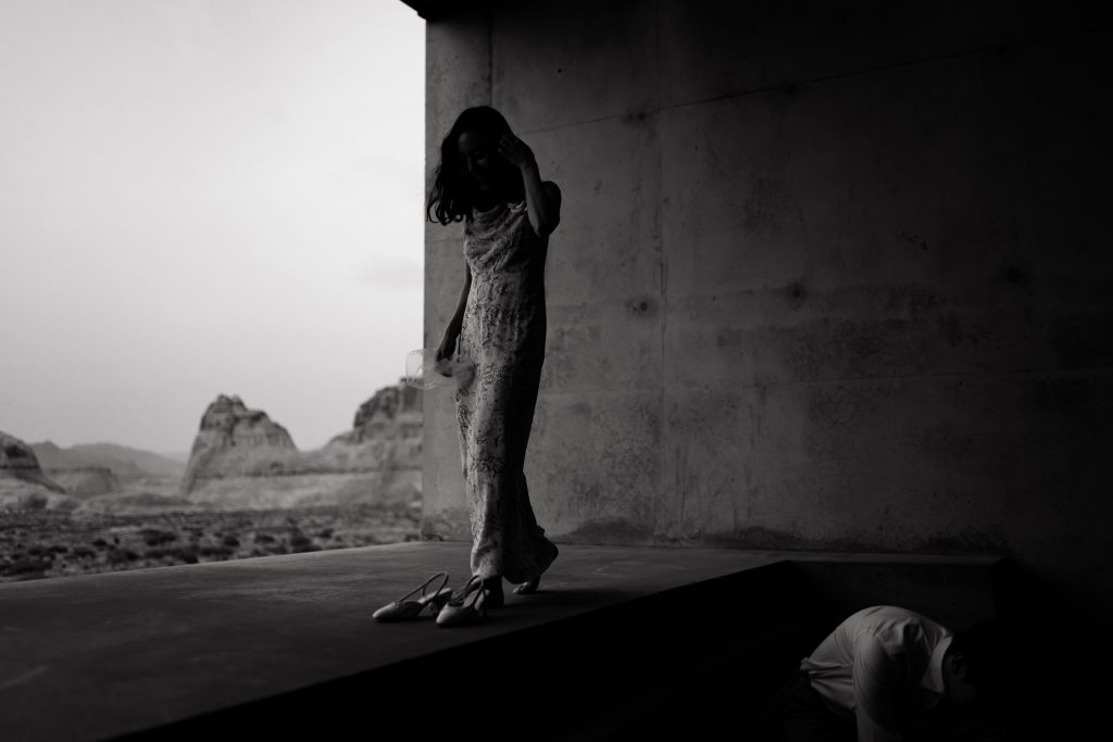 Woman takes her shoes off at her luxury room in the dessert.