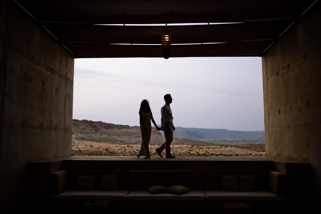 Silouetted couple walking back into their modern concrete room.