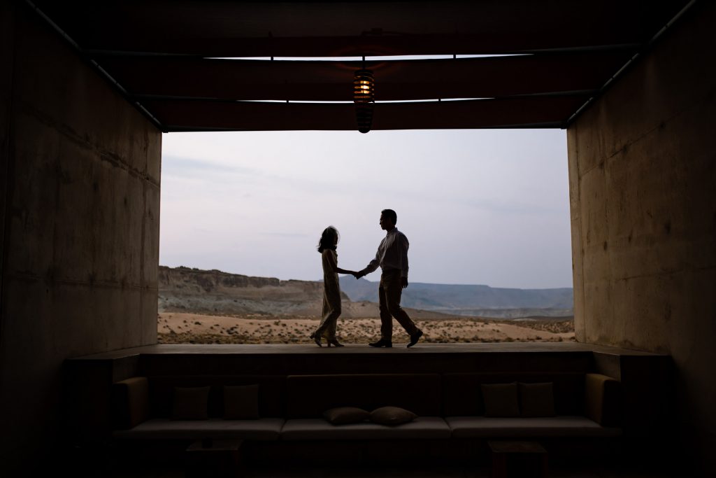 Silouetted couple in modern space with the dessert in the back.