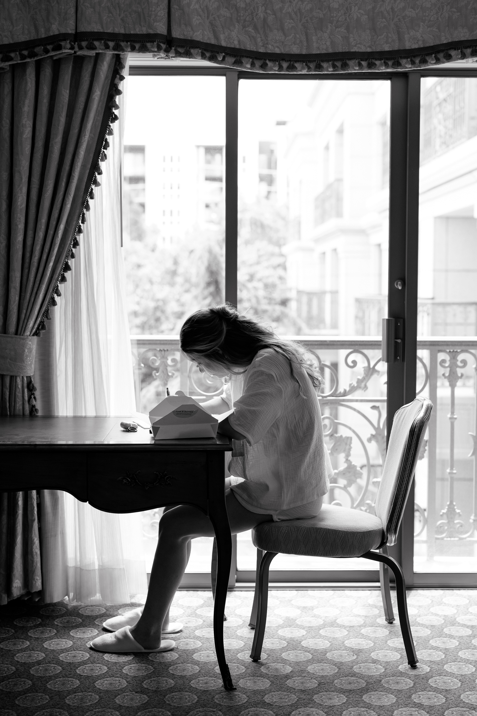 a bride writes her vows to her husband in front of a window